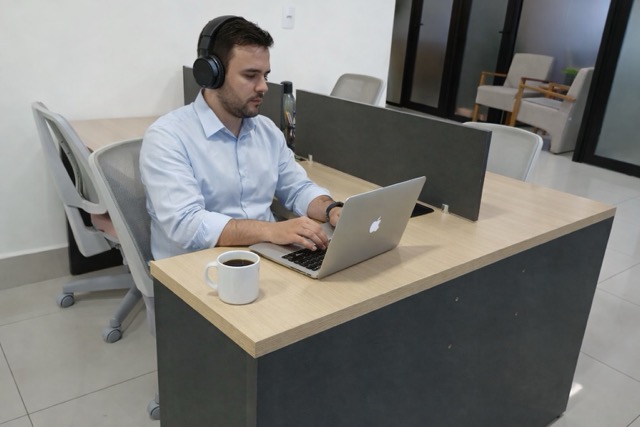 Profissional trabalhando em estação de coworking da iSpaces em Goiânia, com estrutura moderna integrada a escritório virtual e endereço fiscal.